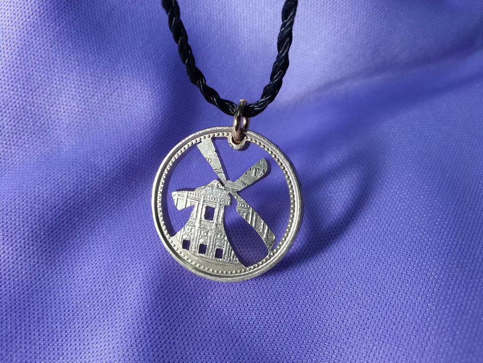 A windmill logo cut coin pendant
